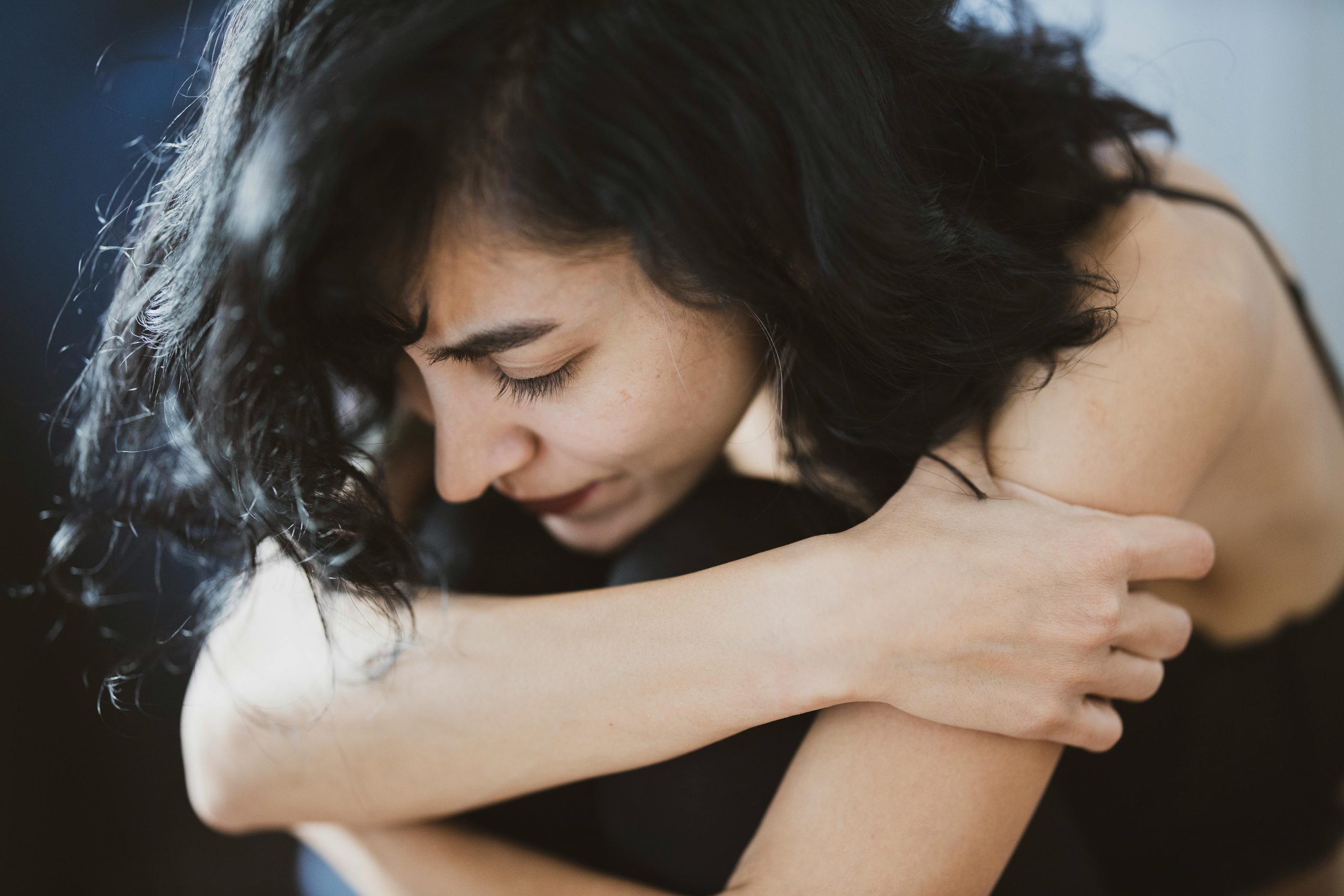 woman feeling alone and scared huddled and curled up