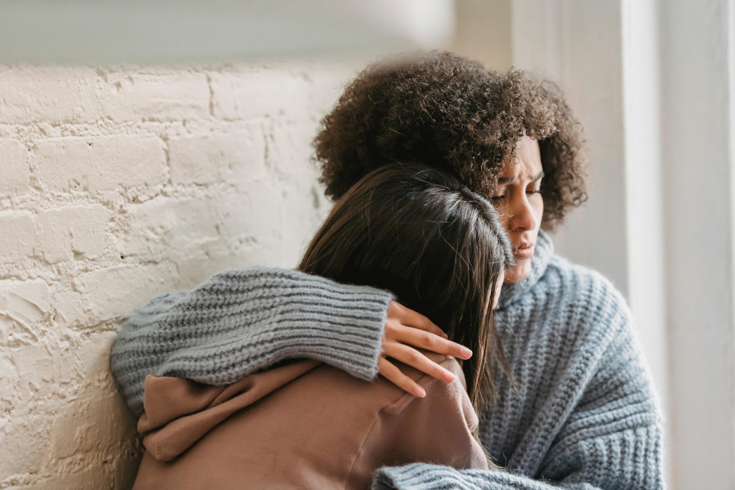 a woman comforting a friend who is struggling unplanned pregnancy what to do