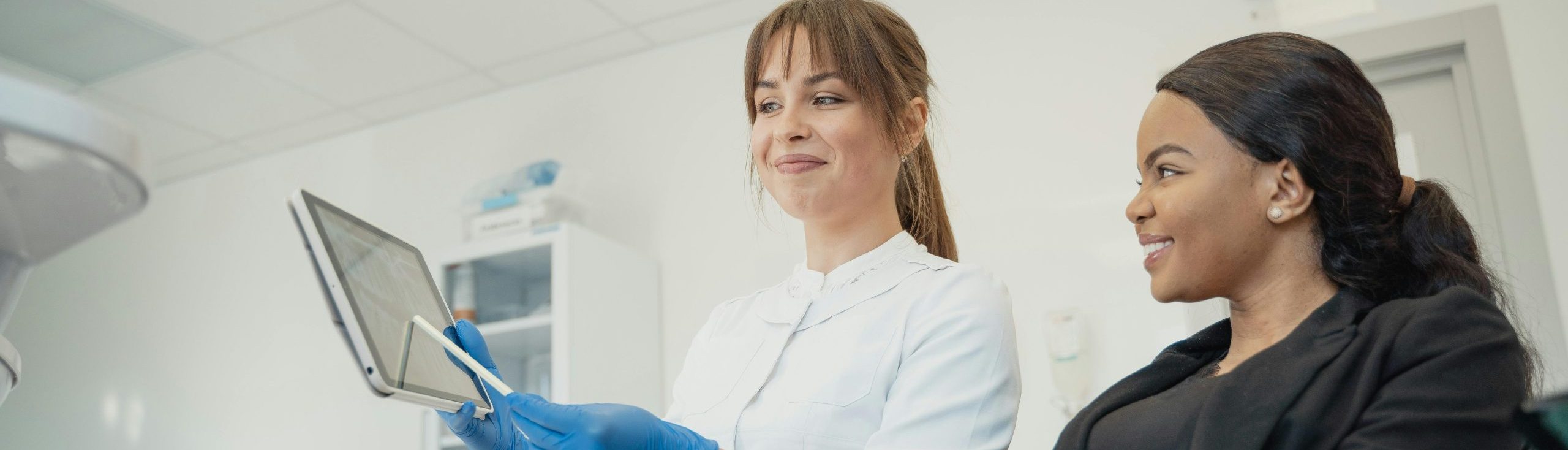 doctor showing woman information on a screen patient in an office